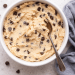 Bowl of creamy cottage cheese cookie dough with chocolate chips and a spoon, perfect for a high-protein no-bake treat
