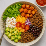 High-protein cottage cheese taco bowl with avocado, black beans, lettuce, and sweet potatoes, served in a healthy lunch recipe.
