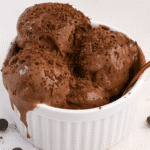 Creamy chocolate cottage cheese ice cream in a white bowl topped with shaved chocolate