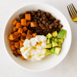 Ground beef sweet potato cottage cheese bowl with avocado served in a white bowl