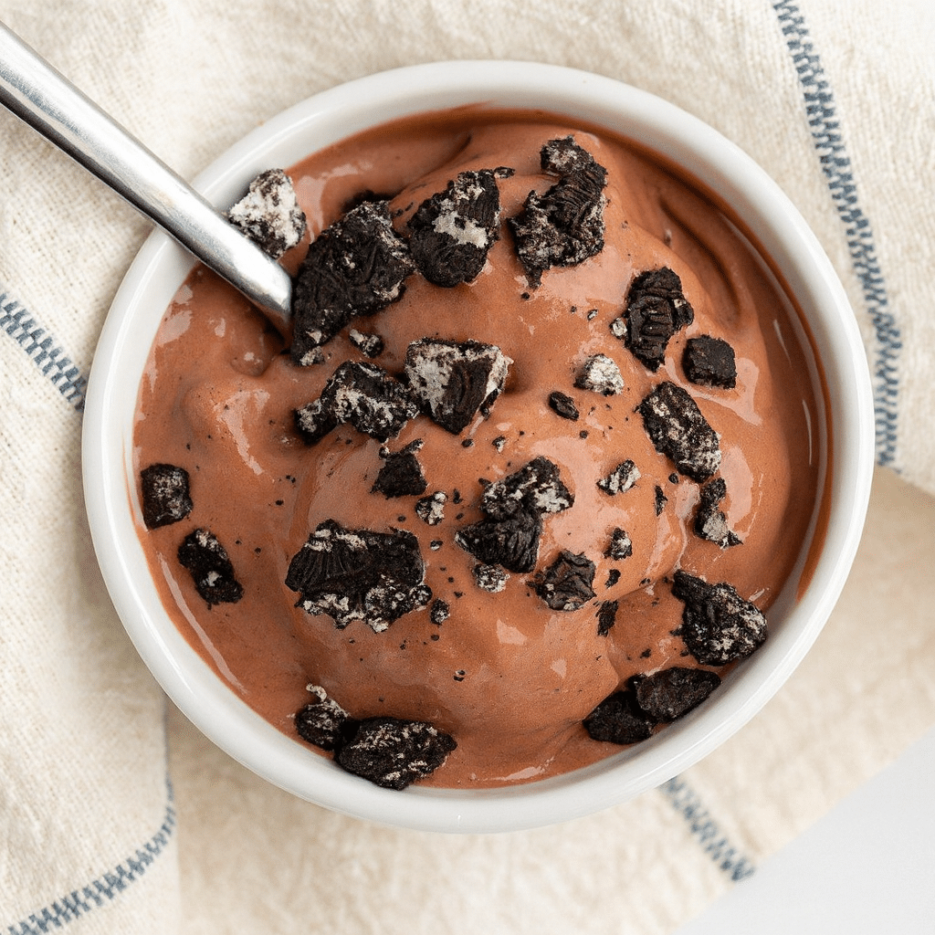 Rich and creamy chocolate cottage cheese ice cream made in a Ninja Creami, topped with crushed chocolate cookies in a white bowl